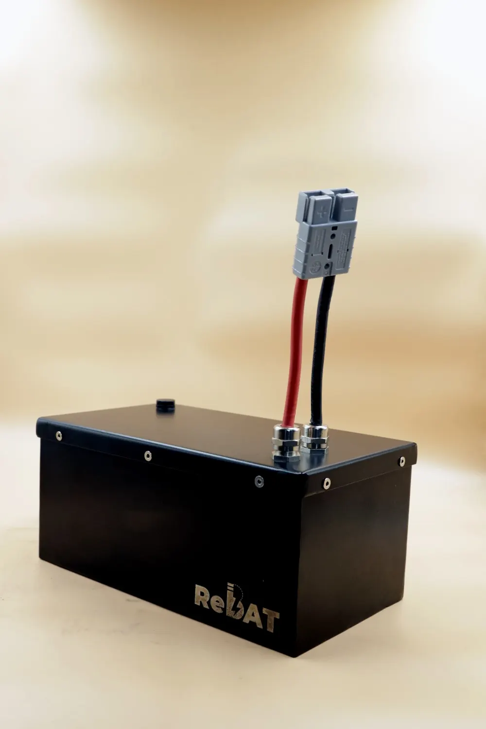 A black ReBAT battery pack with red and black leads and a grey connector