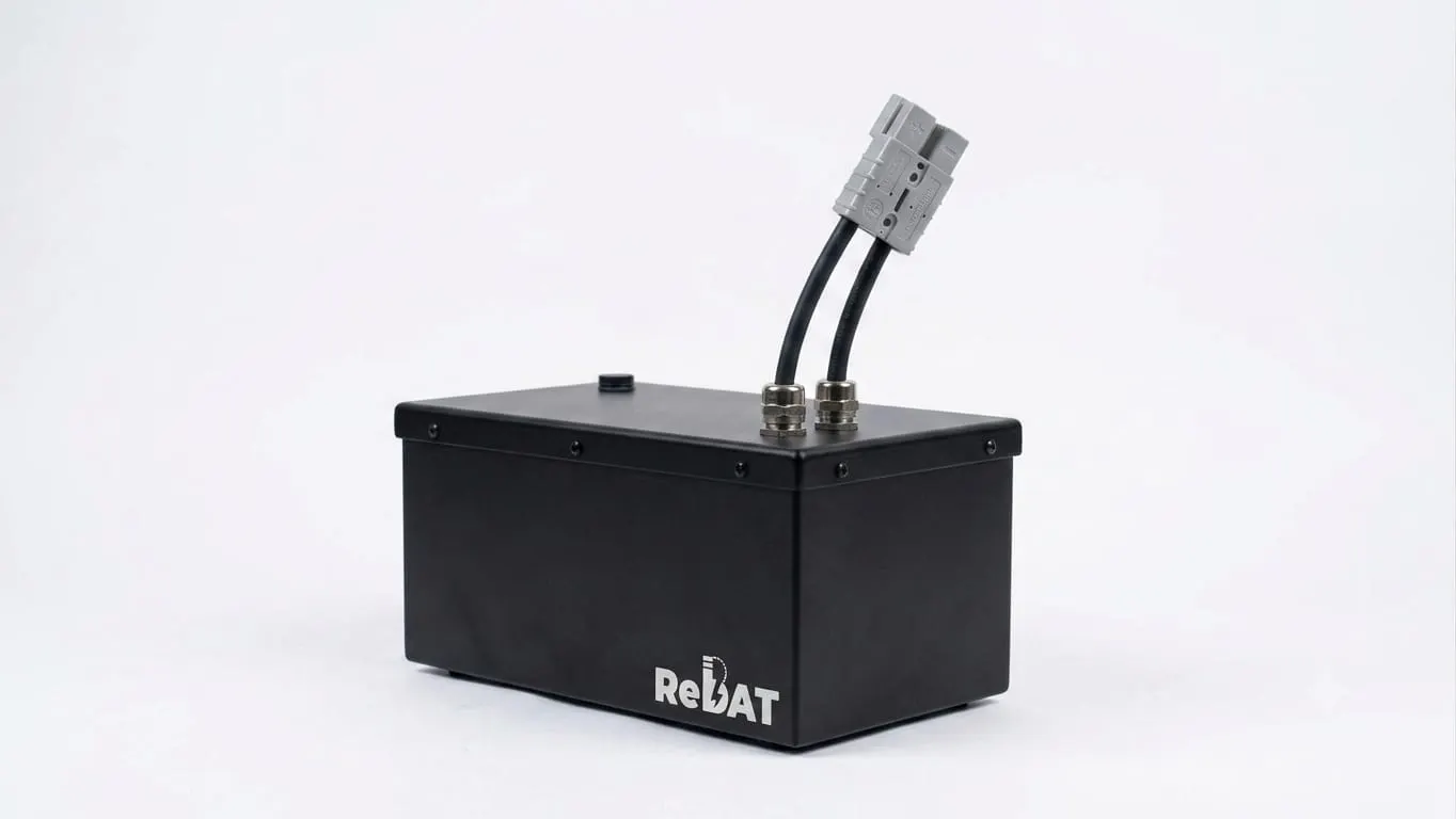 A black ReBAT battery pack on a white background with a grey twin connector