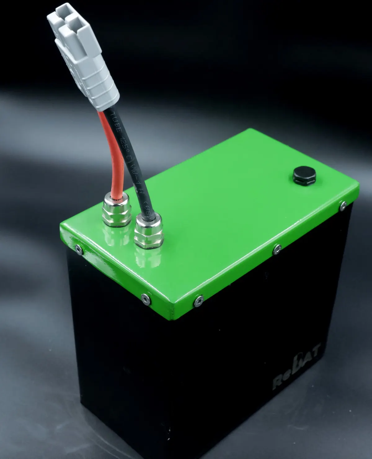 A ReBAT battery pack with a green lid, terminal posts and a grey connector lead
